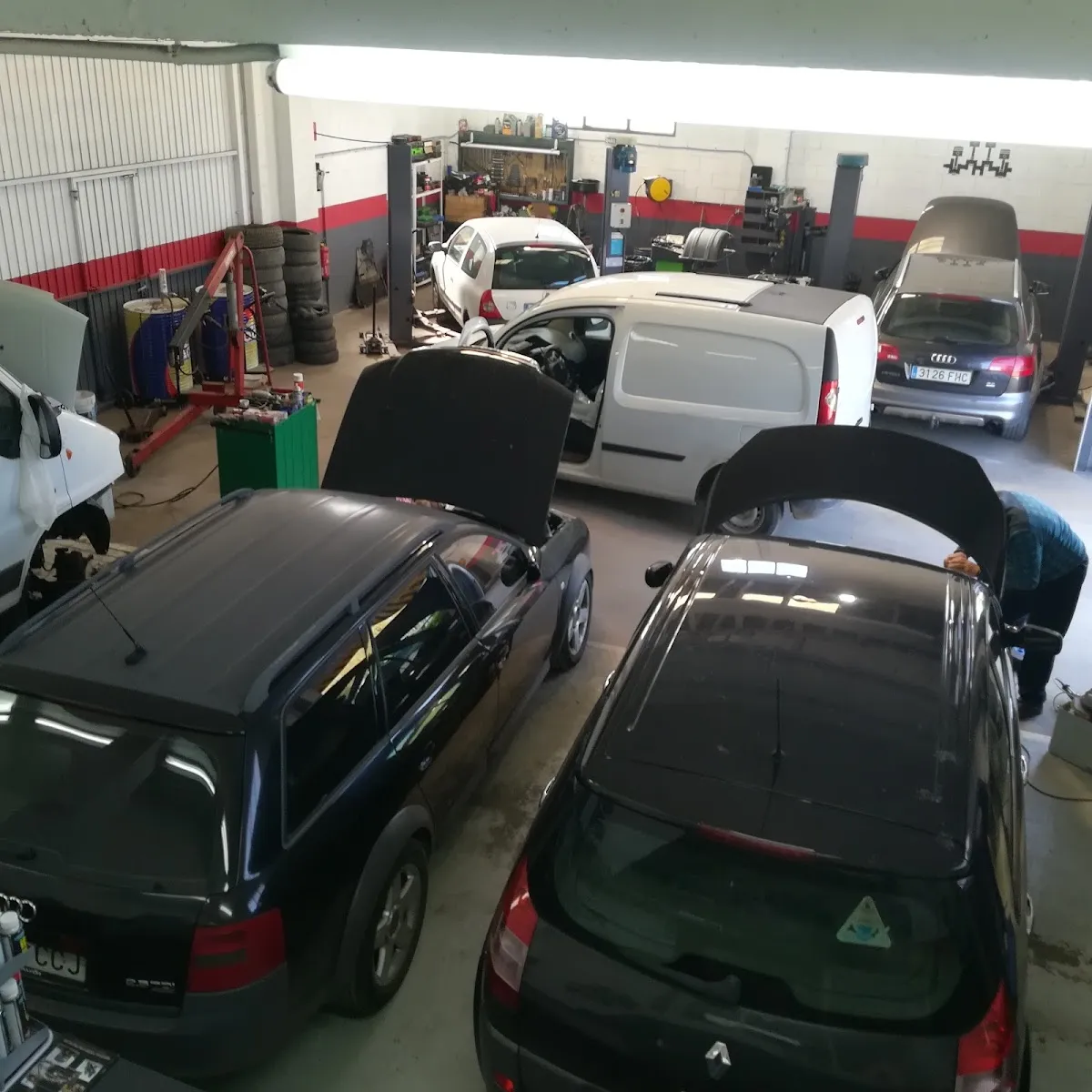 Interior del taller Potenza Automoció: coches en los elevadores y zona de trabajo ordenada